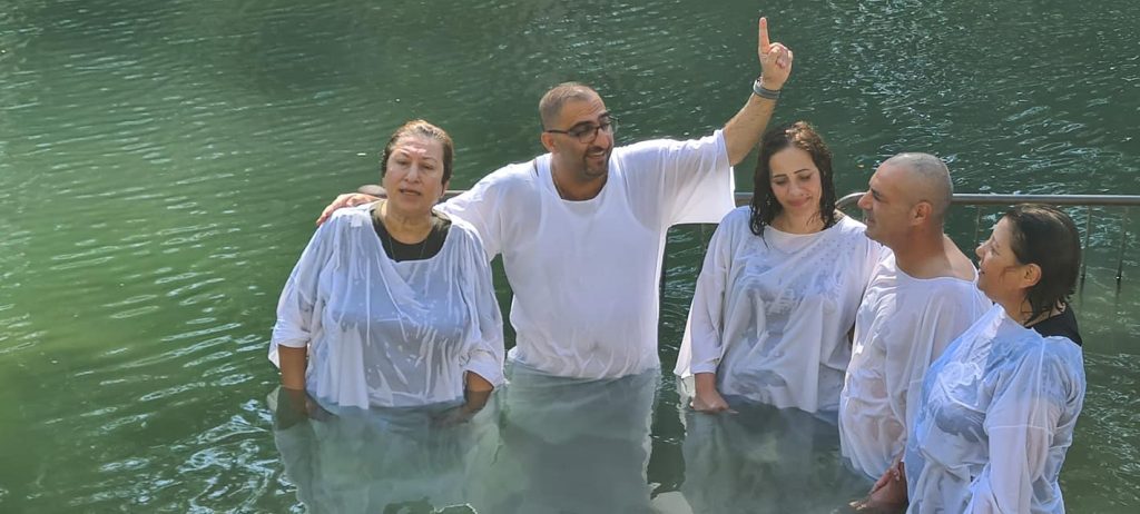 Pastor Saleem Shalash baptizing four people in the Jordan River.