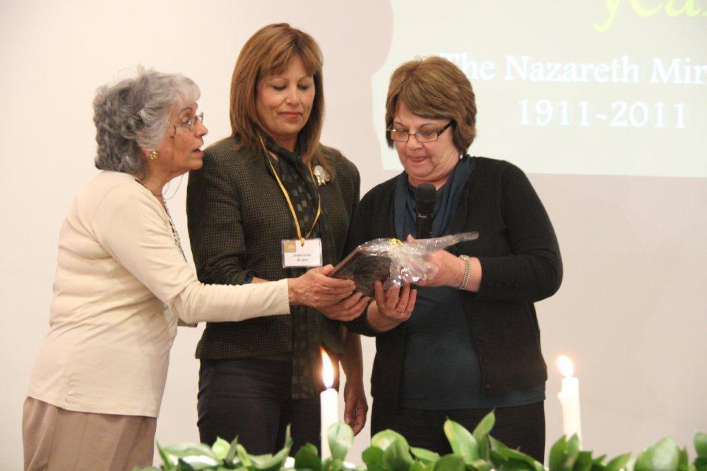 Rhadia Shurrush Qupty gives a plaque to her sisters from the orphanage Lenore and Debby Lindsey