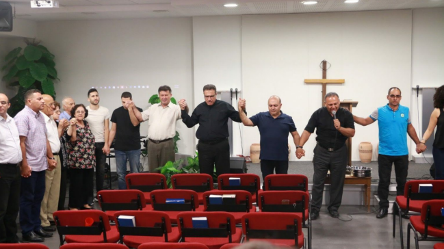 Pastors of different churches praying together, and Pastor Khalid present for support